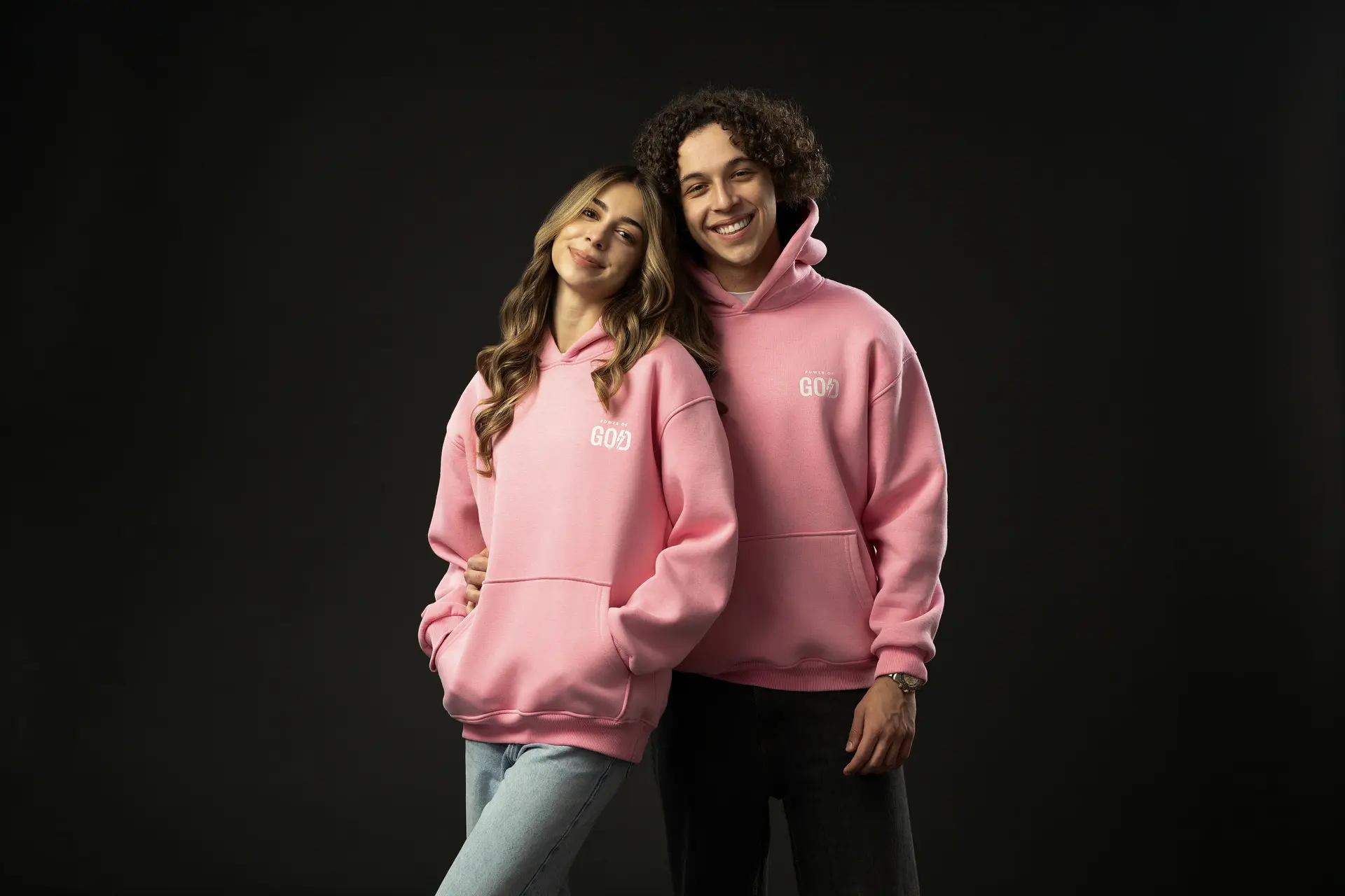 Two people wearing pink Power of God hoodies